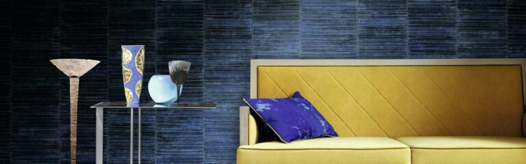 Ein gelb-blauer Stuhl vor einer blauen Wand. Raumausstattung Merget | Goethestraße 43 | 63814 Mainaschaff