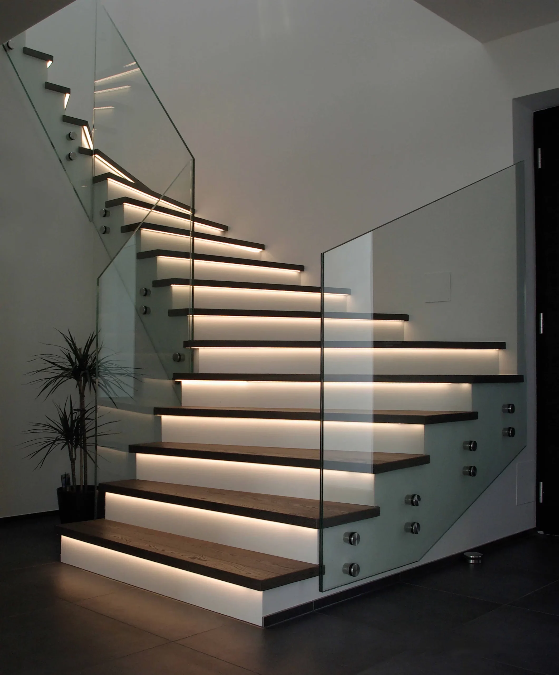 Eine moderne Treppe mit Glasgeländer und LED Beleuchtung an den Treppen - Stufen. Raumausstattung Merget | Goethestraße 43 | 63814 Mainaschaff